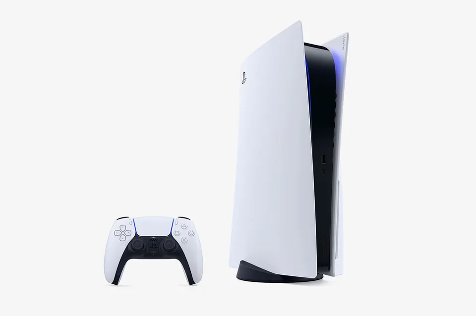 Weiße stehende Spielkonsole mit schwarzen Innenflächen und blauem Leuchtrand, links daneben ein passender weißer Controller auf hellem Hintergrund.